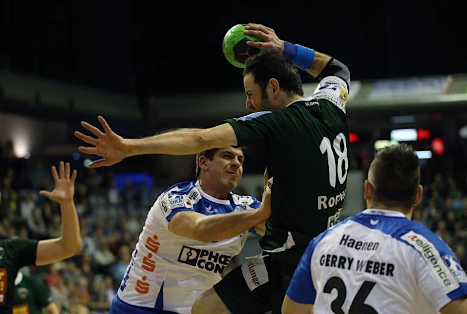 Füchse-Spieler Iker Romero Fernandez (M.) beim Wurf gegen Rolf Hermann (l.) und Arjan Hänen (r.) vom TBV Lemgo.