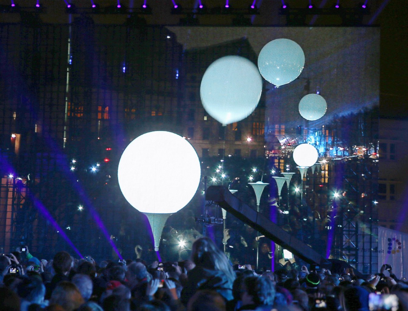 Zuschauer verfolgen auf einer Leinwand wie Ballons der "Lichtgrenze" aufsteigen.
