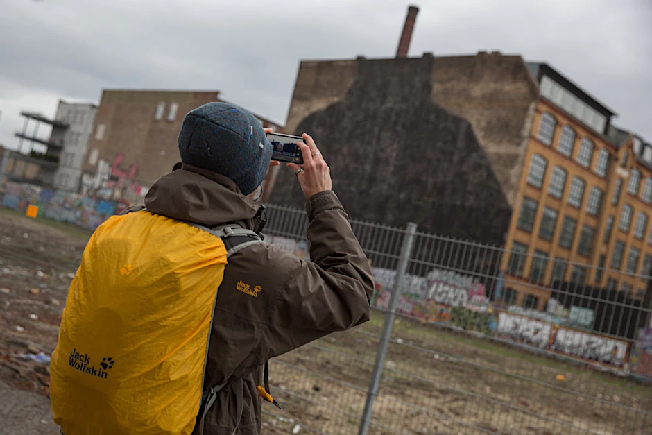 Eines der bekanntesten Streetart-Wandbilder Berlins wurde übermalt: Die Maskenmänner an der Cuvry-Brache in Kreuzberg sind unter einer schwarzen Fläche verschwunden.