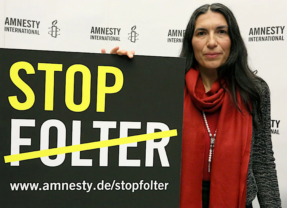 Selmin Caliskan, Generalsekretärin von Amnesty International in Deutschland, präsentiert das Plakat zur globalen Kampagne gegen Folter.