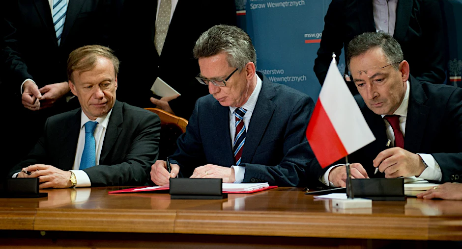 Der deutsche Botschafter in Polen, Rolf Wilhelm Nikel (v.l.), Bundesinnenminister Thomas de Maizière und sein polnischer Amtskollege unterzeichnen in Zgorzelec das Polizeiabkommen.