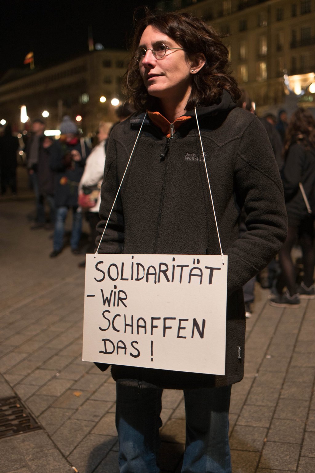 Eine Frau trägt auf dem Pariser Platz ein Schild mit der Aufschrift "Solidarität - Wir schaffen Das!".