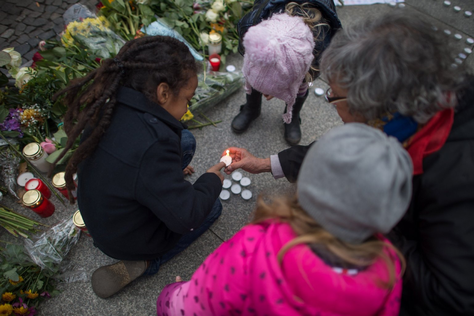 Kinder zünden vor der französischen Botschaft in Berlin Kerzen an.