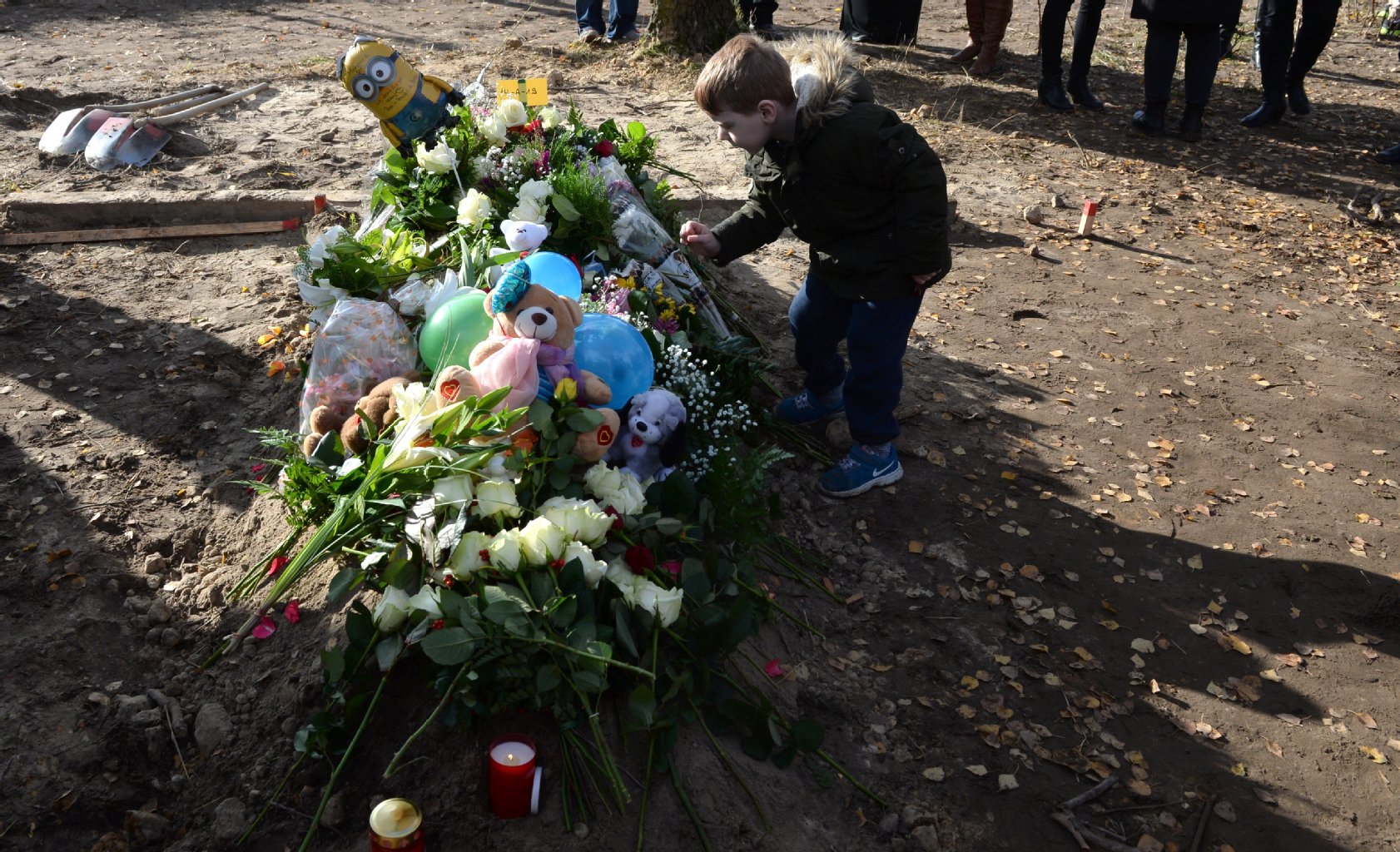 Ein kleiner Junge steht am 05.11.2015 im islamischen Teil des Landschaftsfriedhofs Gatow in Berlin bei der Beerdigung des getöteten Flüchtlingsjungen Mohamed neben dem Grab.