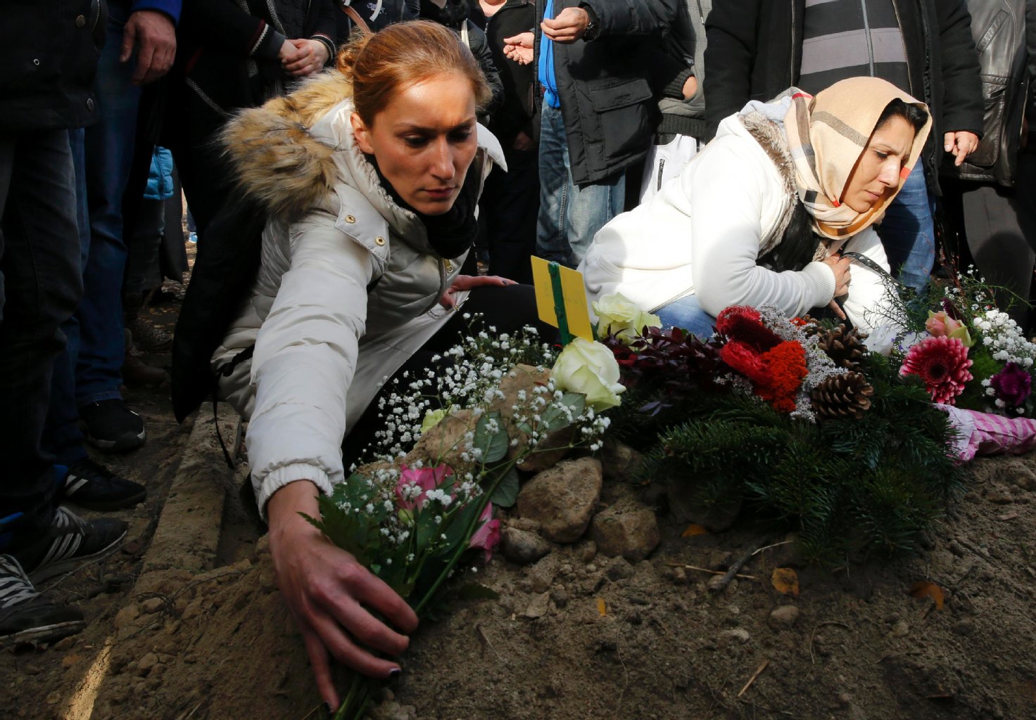Trauernde legen bei der Beerdigung Blumen auf das Grab von Mohamed am 05.11.2015