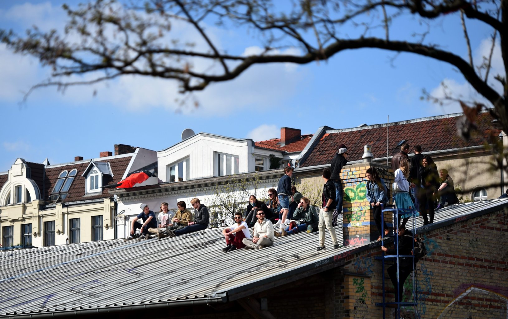 Da wollten wohl ein paar Leute ihre Ruhe - Besucher des Myfests sitzen am Görlitzer Park auf einem Dach.