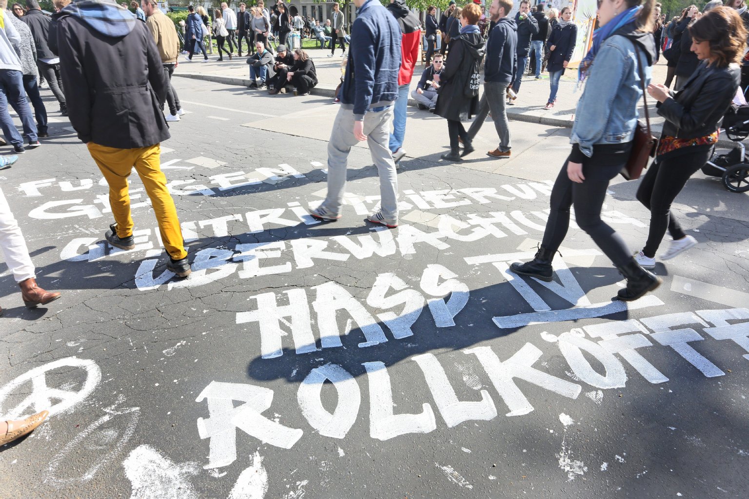"Fuck gegen Gentrifizierung, Überwachung, Hass IV, Rollkoffer" steht in großen Lettern auf einer Straße in Kreuzberg.