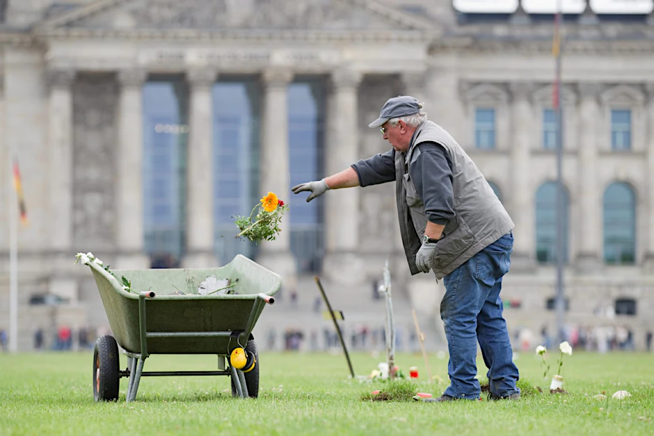 Blumen in die Schubkarre: Mitarbeiter einer privaten Firma die Wiese vor dem Reichstag nach der Demonstration vom Wochenende.