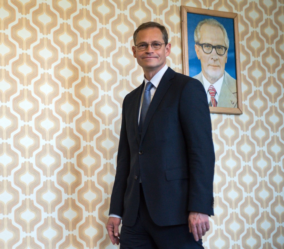 Michael Müller (SPD), Regierender Bürgermeister von Berlin, neben einem Porträt von Erich Honecker.