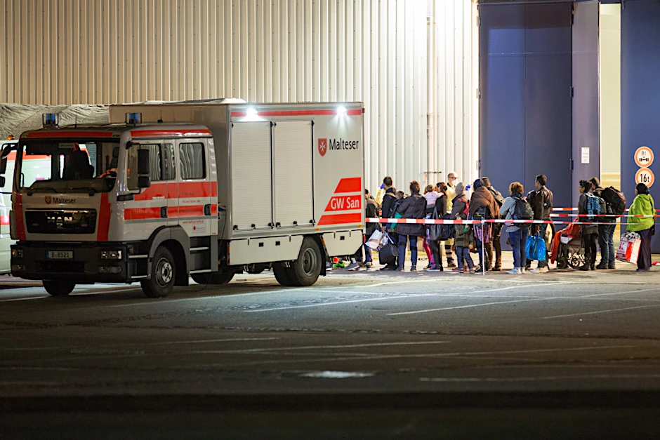 Flüchtlinge warten vor der Halle 26 auf dem Messegelände.