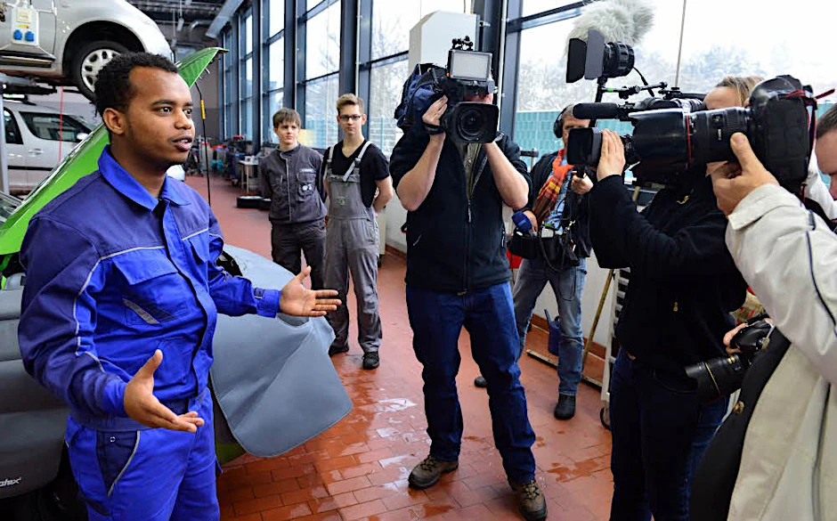 So sehen wir sie gern: Der Flüchtling Michael Telcom aus Eritrea zeigt Journalisten in einer Autowerkstatt in Thüringen seinen Arbeitsplatz.