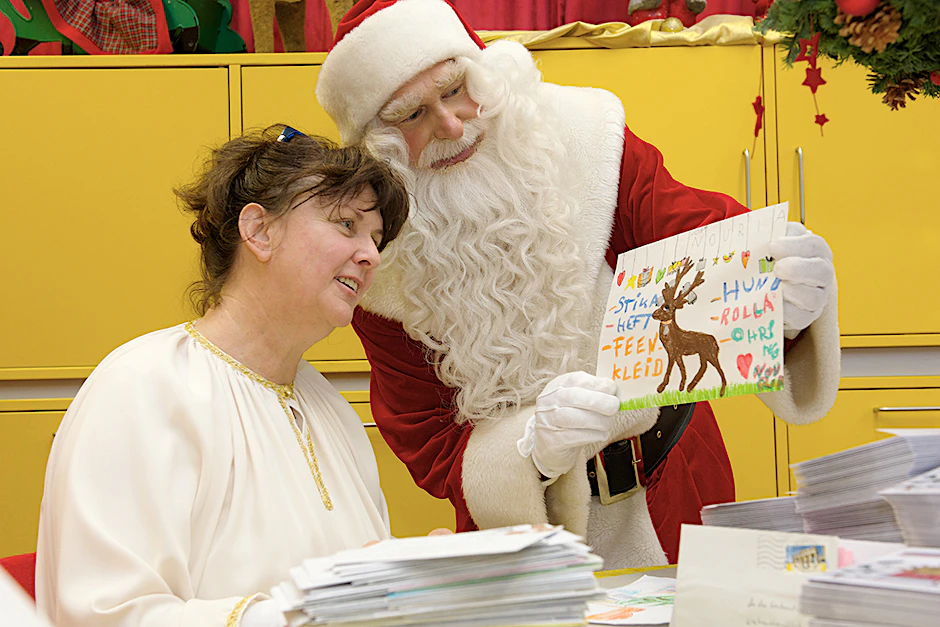 Saisonkräfte, die Wunschzettel studieren: Engel Conny und der Weihnachtsmann.