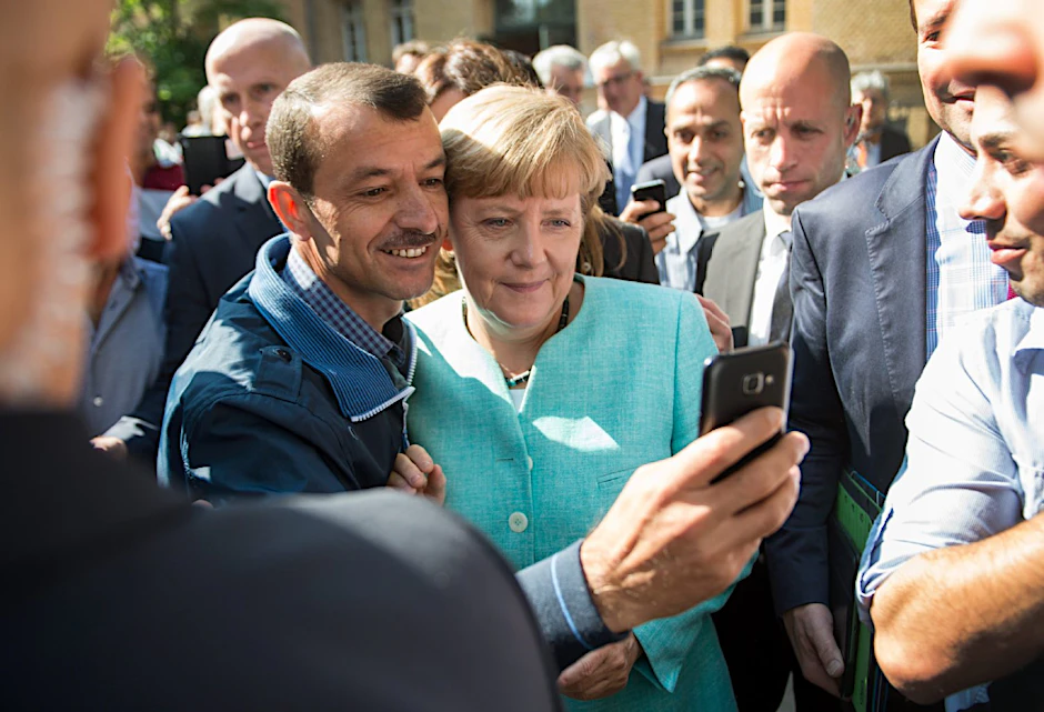 Bundeskanzlerin Angela Merkel (CDU) lässt sich am 10.09.2015 nach dem Besuch der Erstaufnahmeeinrichtung für Asylbewerber der Arbeiterwohlfahrt (AWO) in Berlin-Spandau für ein Selfie zusammen mit dem Flüchtling Schakir Kedida aus Mossul (Irak) fotografieren.