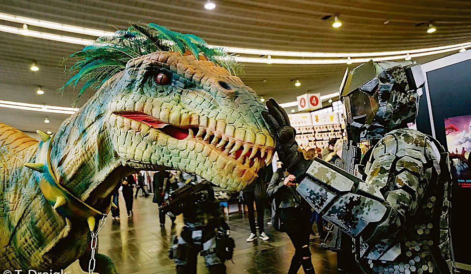 Nur möglich auf der Comic Con: Ein  Raptor aus dem Film „Jurassic Park“ trifft auf einen Kämpfer  aus dem Ego-Shooter-Spiel „Halo“.