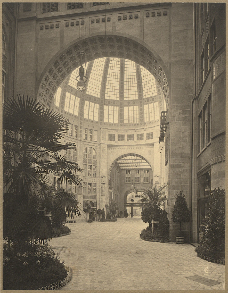Blick in den zentralen Kuppelsaal und zum Ausgang Richtung Friedrichstraße. Die Ausstattung ist edel, Palmen verbreiten ein exotisches Flair.
