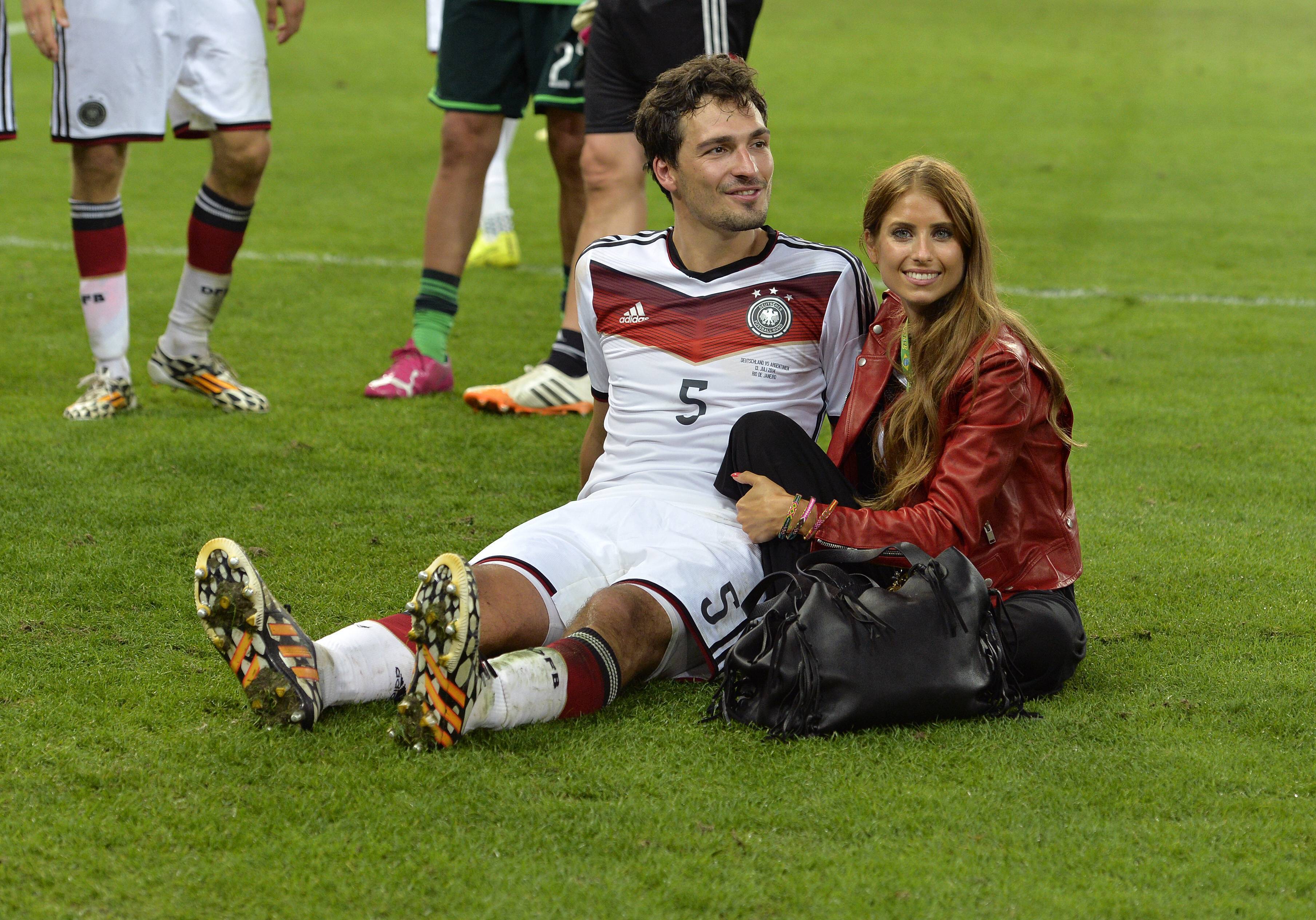 Mats Hummels mit seiner Ehefrau Cathy Fischer (r.) weilen auf dem Rasen nach dem WM-Finale 2014.