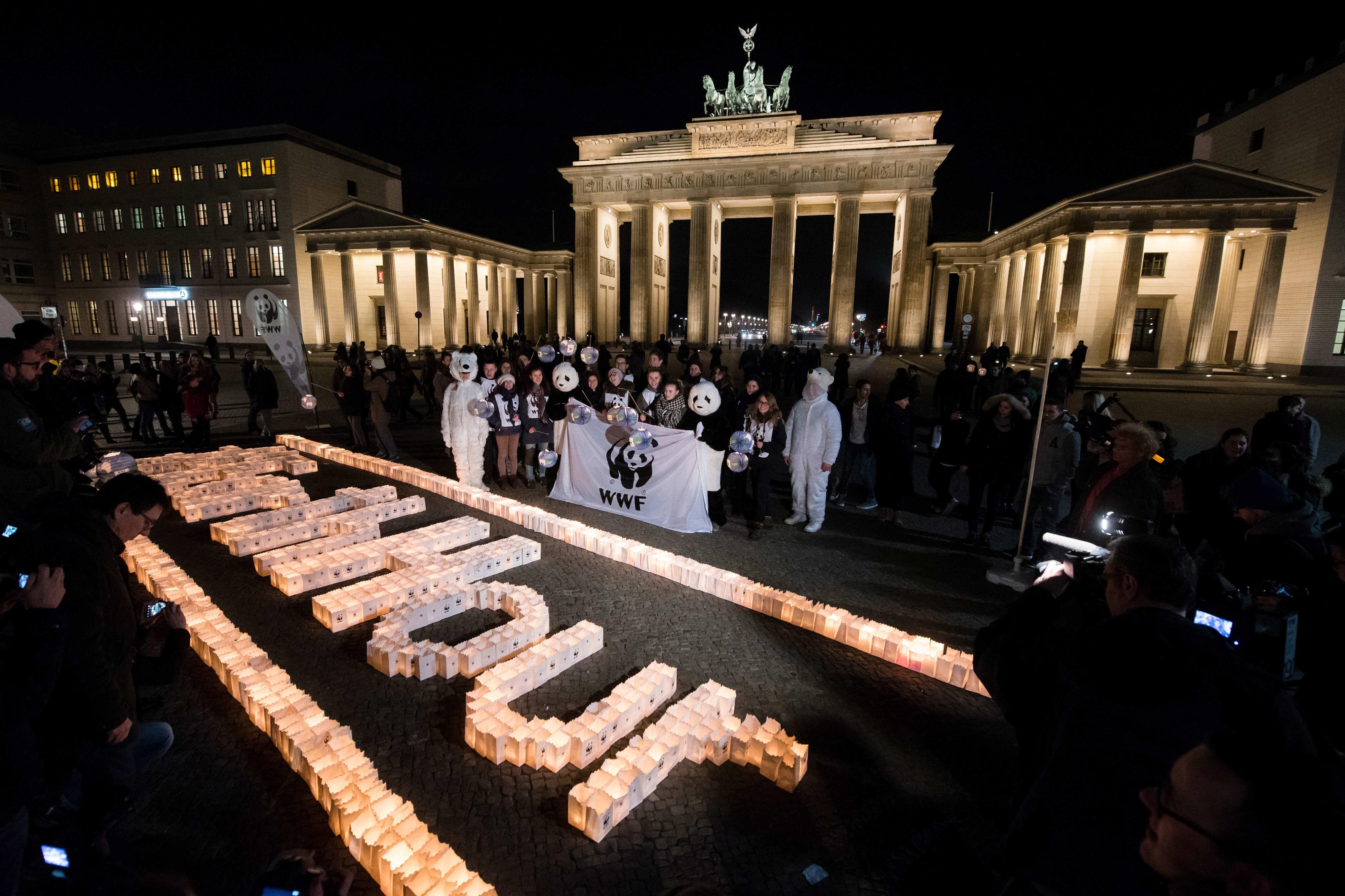 Aktivisten des World Wildlife Fund (WWF) stehen am 19.03.2016 vor dem  Schriftzug "#Earthhour" vor dem Brandenburger Tor in Berlin.