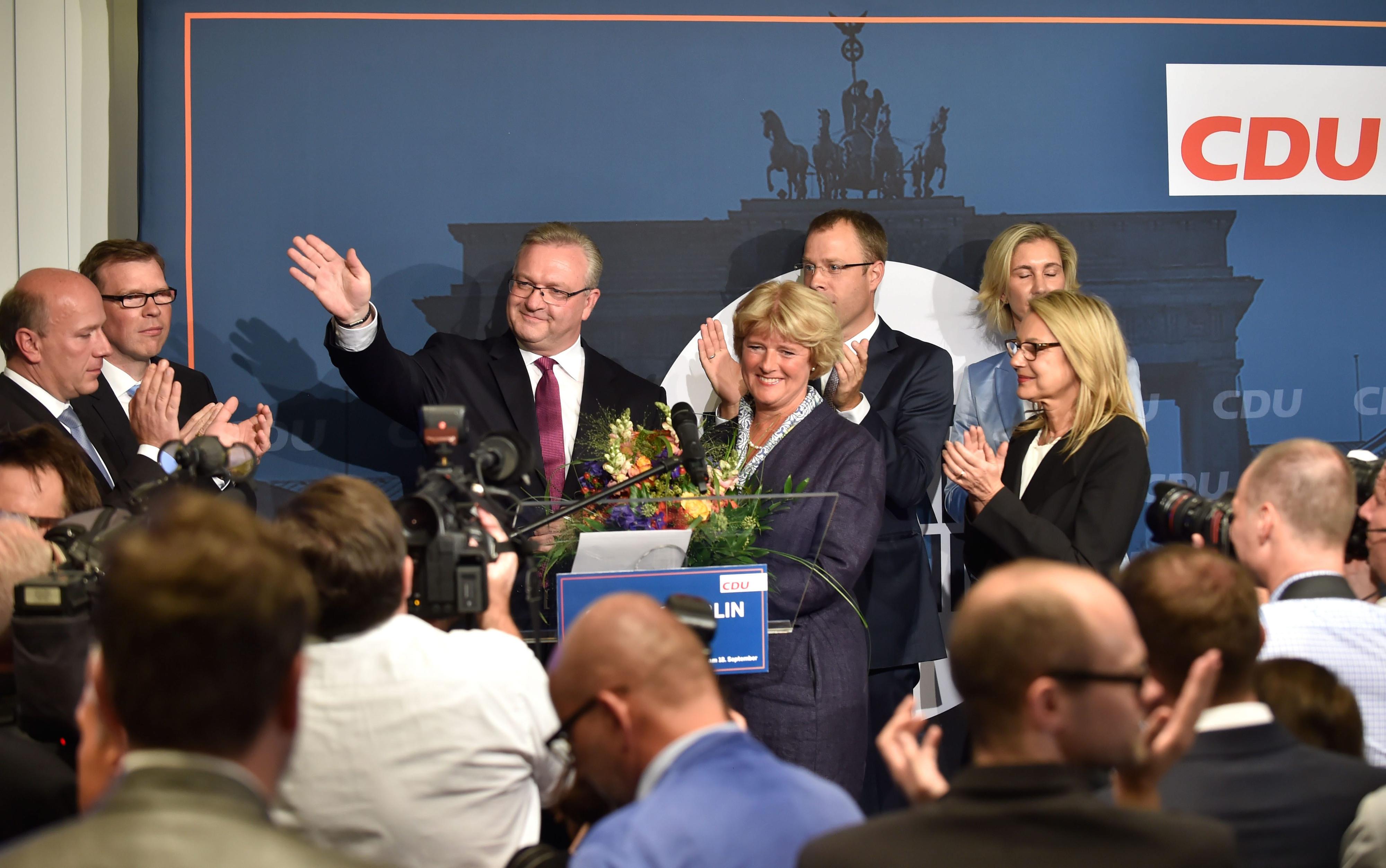 Der Spitzenkandidat der CDU, Innensenator Frank Henkel (l), steht nach Bekanntgabe der ersten Ergebnisse im Abgeordnetenhaus mit Kulturstaatsministerin Monika Grütters (CDU), Sozialminister Mario Czaja auf der Bühne.