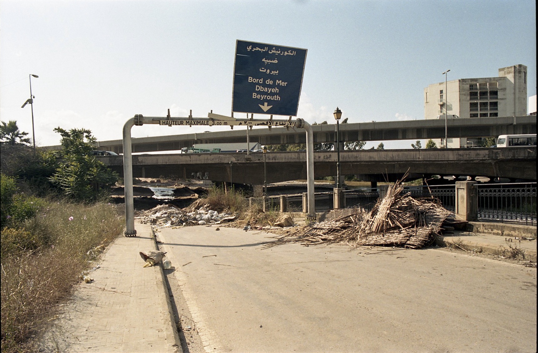 Autobahnausfahrt zwischen Beirut und Jounieh Nebenan fließt der verschmutzte Fluss Nahr El Kalb, gegenüber thront das Kloster Zouk Mosbeh. Ein Nicht-Ort im belebten Alltag der vorbeiziehenden Pendler auf der vierspurigen, oft gestauten Autobahn, der nebenbei die großen Probleme bei der Müllentsorgung und beim Recycling im Land verdeutlicht.