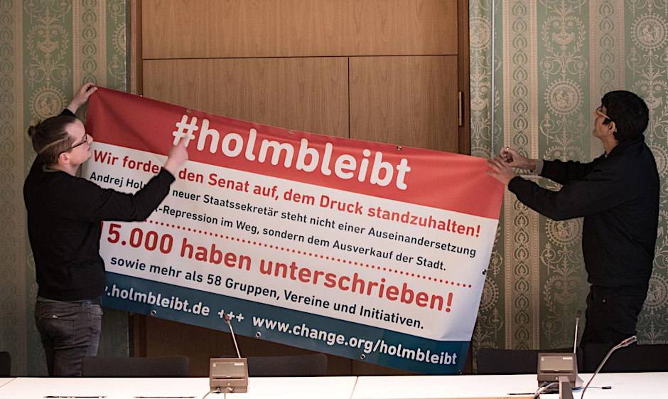 Aktivisten hängen ein Plakat zur Kampagne für Andrej Holm auf. 