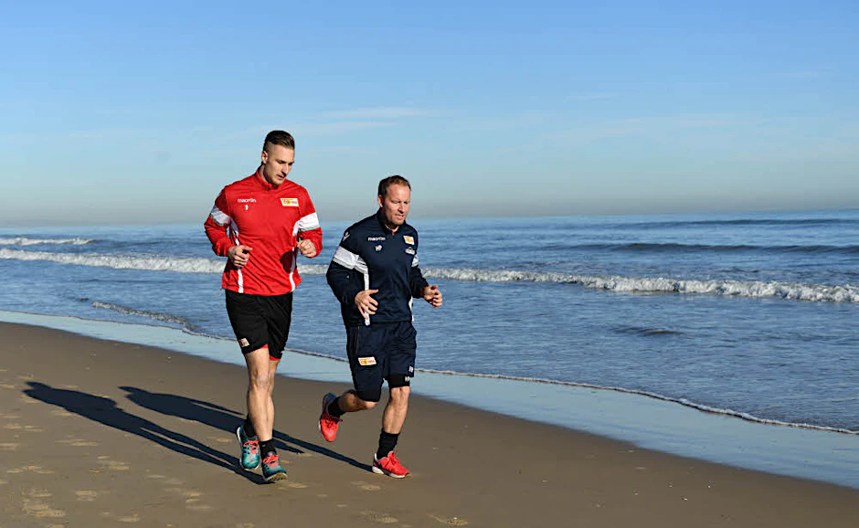 Strand statt Schnee: Sebastian Polter beim lockeren Lauf mit Assistenztrainer Henrik Pedersen.