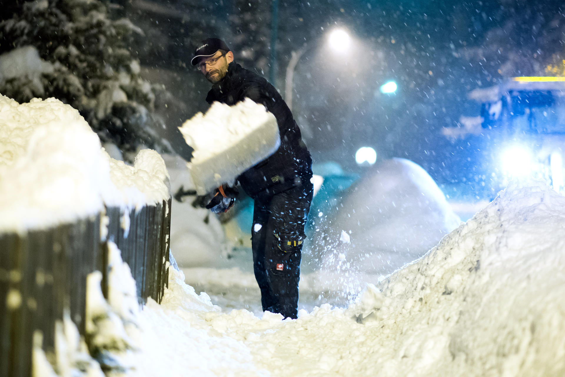 Ein Mann schippt in Braunlage im Oberharz Schnee.