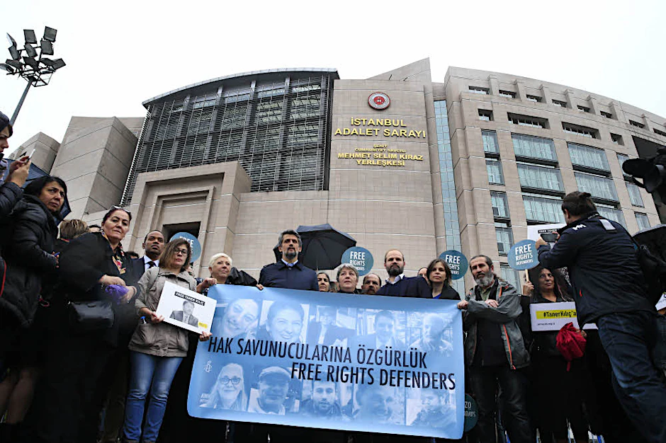 Protest vor dem Gericht in Istanbul: Menschenrechtler halten ein Transparent mit Fotos der Angeklagten .
