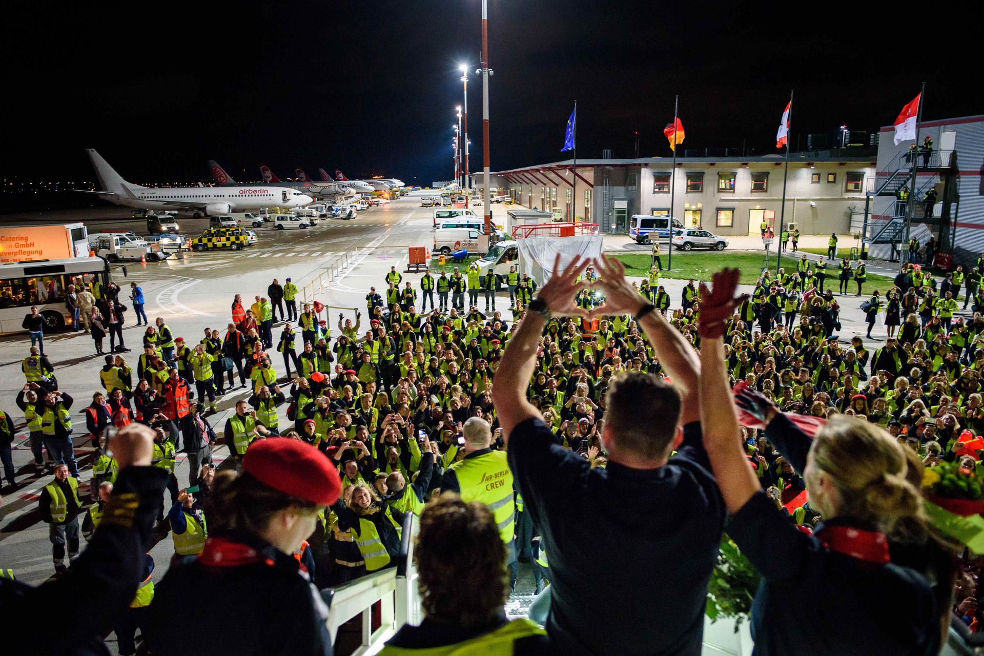 Viele Menschen stehen in Tegel bereit, um die letzte Maschine zu empfangen.