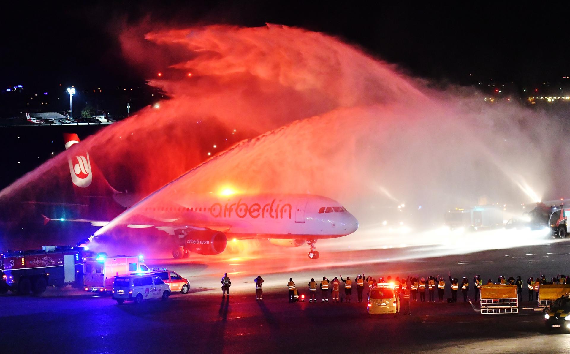 Die letzte Maschine der Fluggesellschaft Air Berlin wird nach der Landung in Tegel von der Feuerwehr auf dem Rollfeld mit Wasserfontänen empfangen.