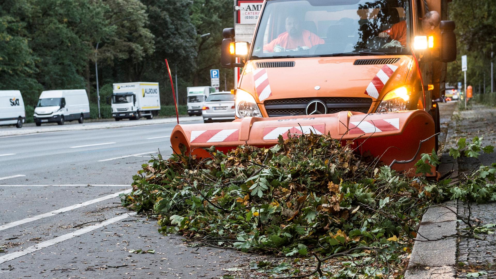 Ein Einsatzfahrzeug der Stadtreinigung BSR schiebt auf der Straße des 17. Juni Äste zusammen.