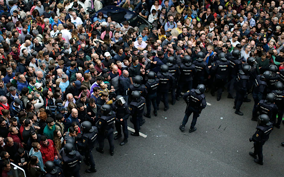 Einheiten der spanischen Nationalpolizei verhindern Menschen den Zugang zu einem Wahllokal in Barcelona.