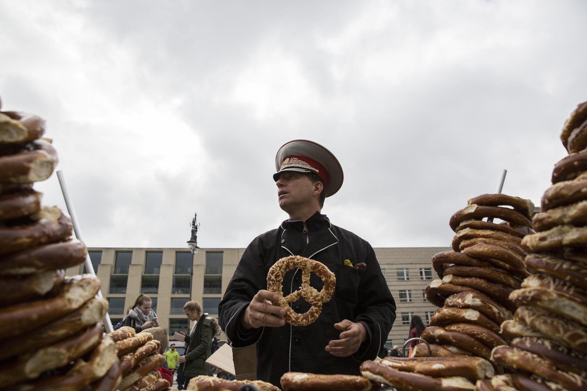 Ein Mann mit sowjetischer Militärmütze verkauft Brezeln am Pariser Platz.