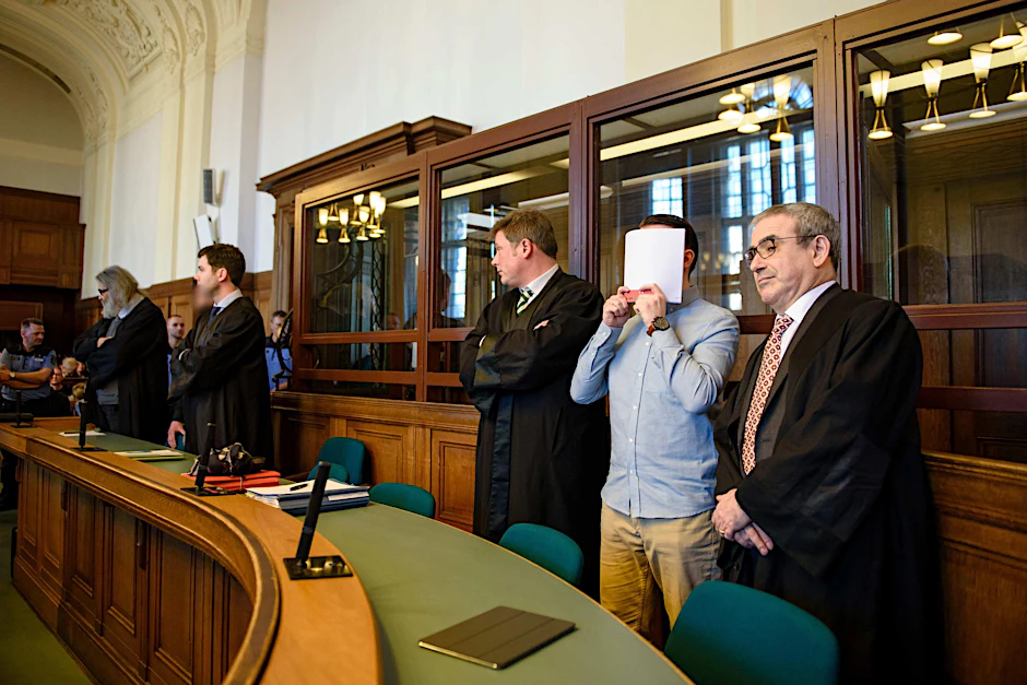 Die Angeklagten Hamdi H. (2.v.r) und Marvin N. (5.v.r, halb verdeckt) stehen am 27.02.2017 in einem Saal des Landgerichtes Berlin zwischen ihren Anwälten. Im ersten Prozess wurden sie wegen Mordes verurteilt.