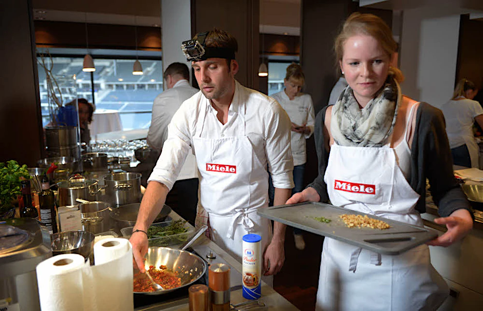 Die Hobby-Köche Anna Peinze und Marko Dietrich beim Gemüse schneiden, Nudelteig kneten und Fisch braten.