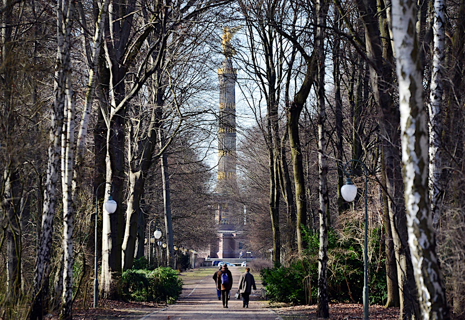 Passanten gehen im Tiergarten in Richtung Siegessäule spazieren. 