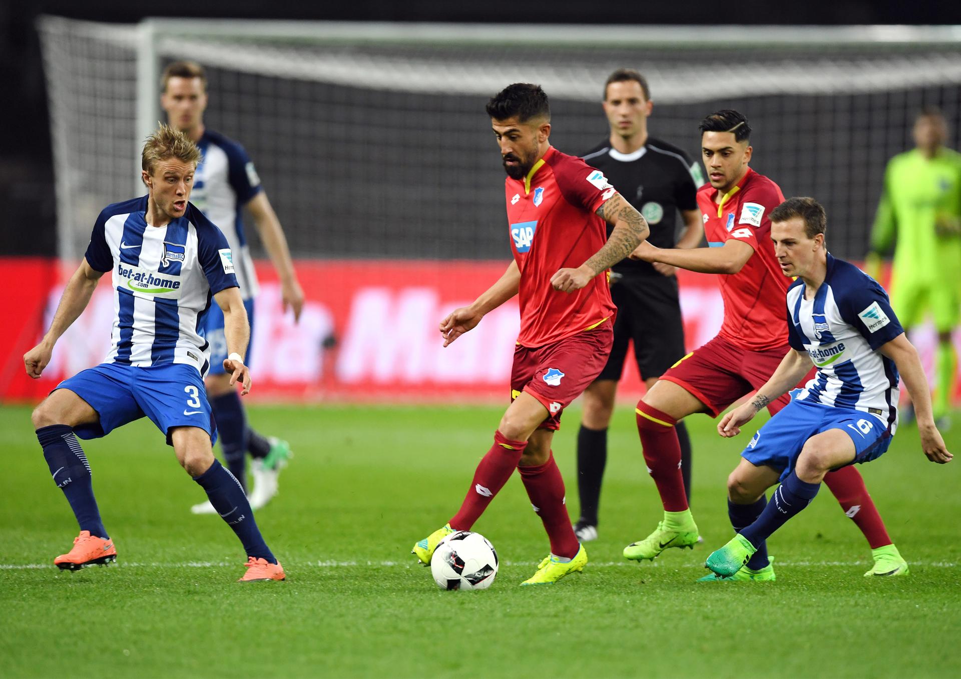 Berlins Per Skjelbred (l) und Vladimir Darida und Hoffenheims Kerem Demirbay (M.) kämpfen um den Ball.