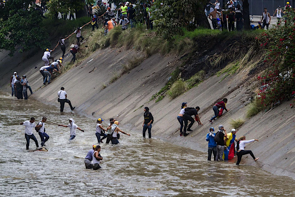 Demonstranten in Caracas fliehen vor der Polizei. 