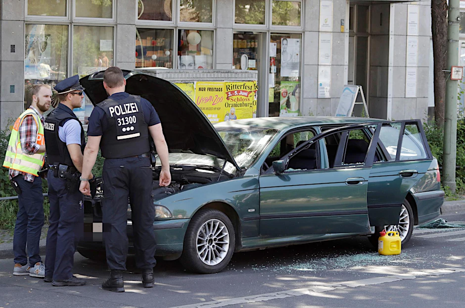 Polizisten stehen am verdächtigen BMW.