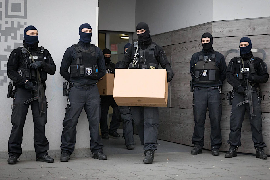 Vermummte Polizisten sichern bei einer Razzia Beweismaterial im Fall Anis Amri.