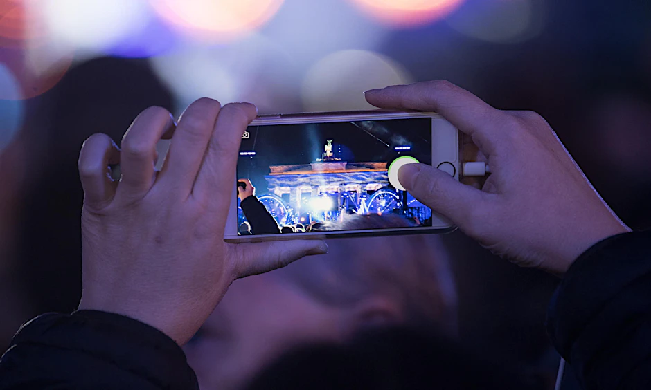 Eine Besucherin fotografiert das Brandenburger Tor mit ihrem Smartphone.