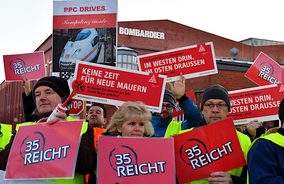 Mit Plakaten stehen am 08.01.2018 in Hennigsdorf Bombardier-Mitarbeiter vor dem Werktor. 