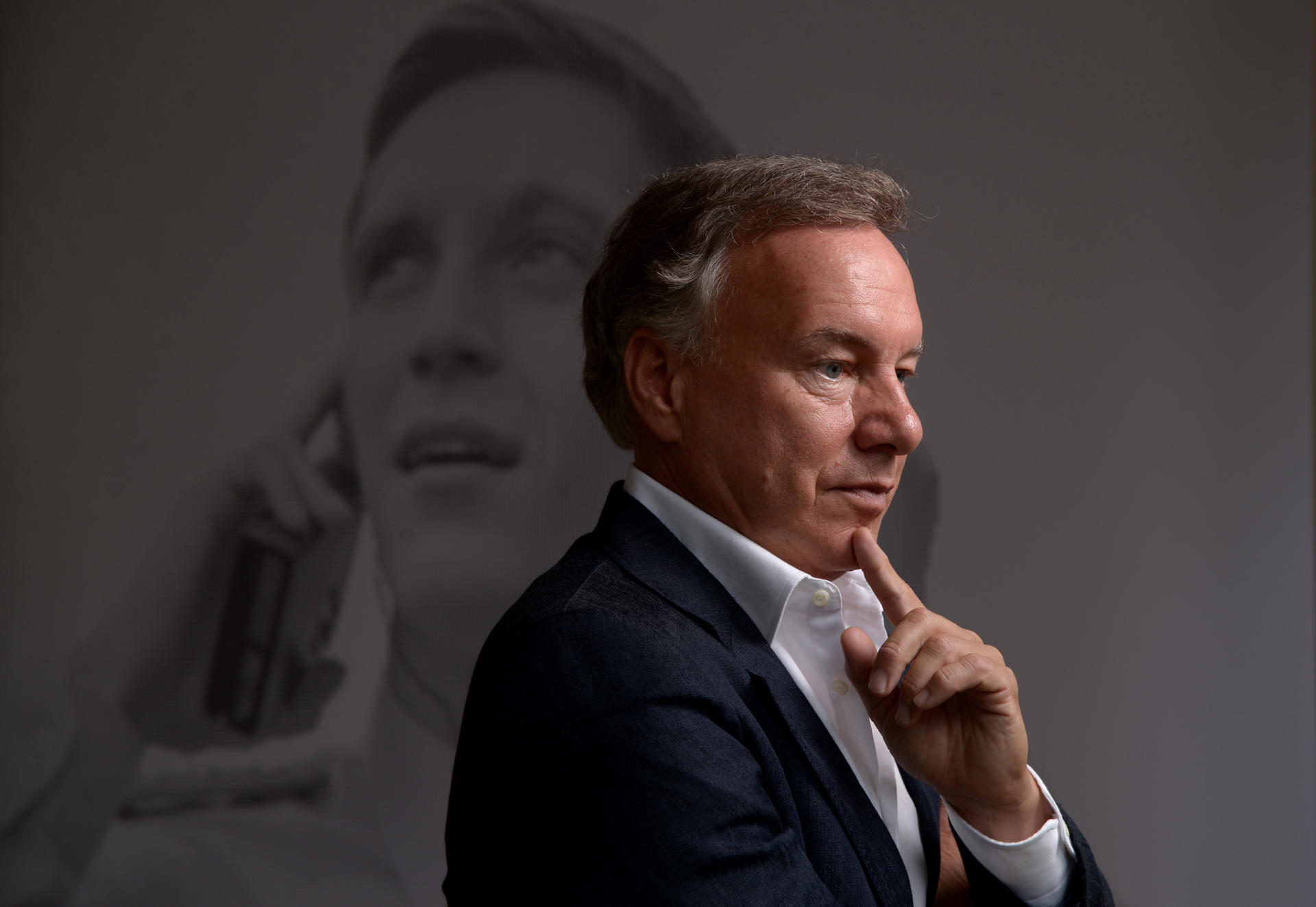 „Je bewusster wir uns mit der eigenen Geschichte beschäftigen, desto selbstbewusster kann man mit ihr umgehen“, sagt Nico Hofmann, Macher unter anderem von „Unsere Mütter, unsere Väter“. Hier posiert er in seinem Büro in Charlottenburg vor einem Bild des jungen Schauspielers Jonas Nay in der international gefeierten Miniserie „Deuschland 83“.