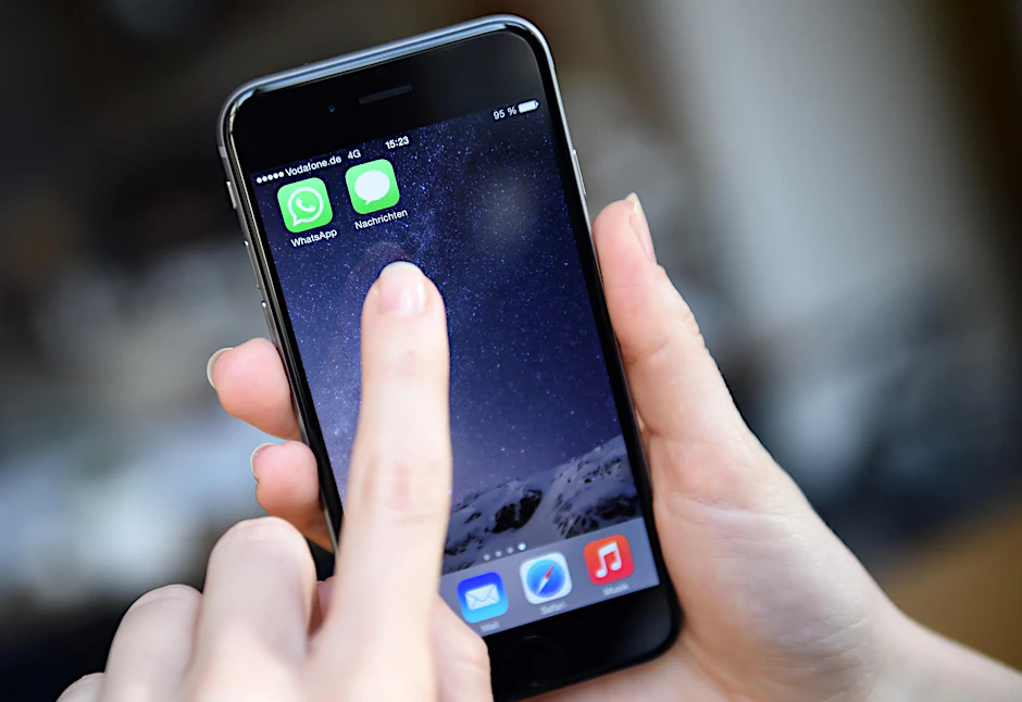 Auf dem Display eines iPhone 6 werden die Symbole der Apps "WhatsApp" und "Nachrichten" (rechts, iMessage), angezeigt.