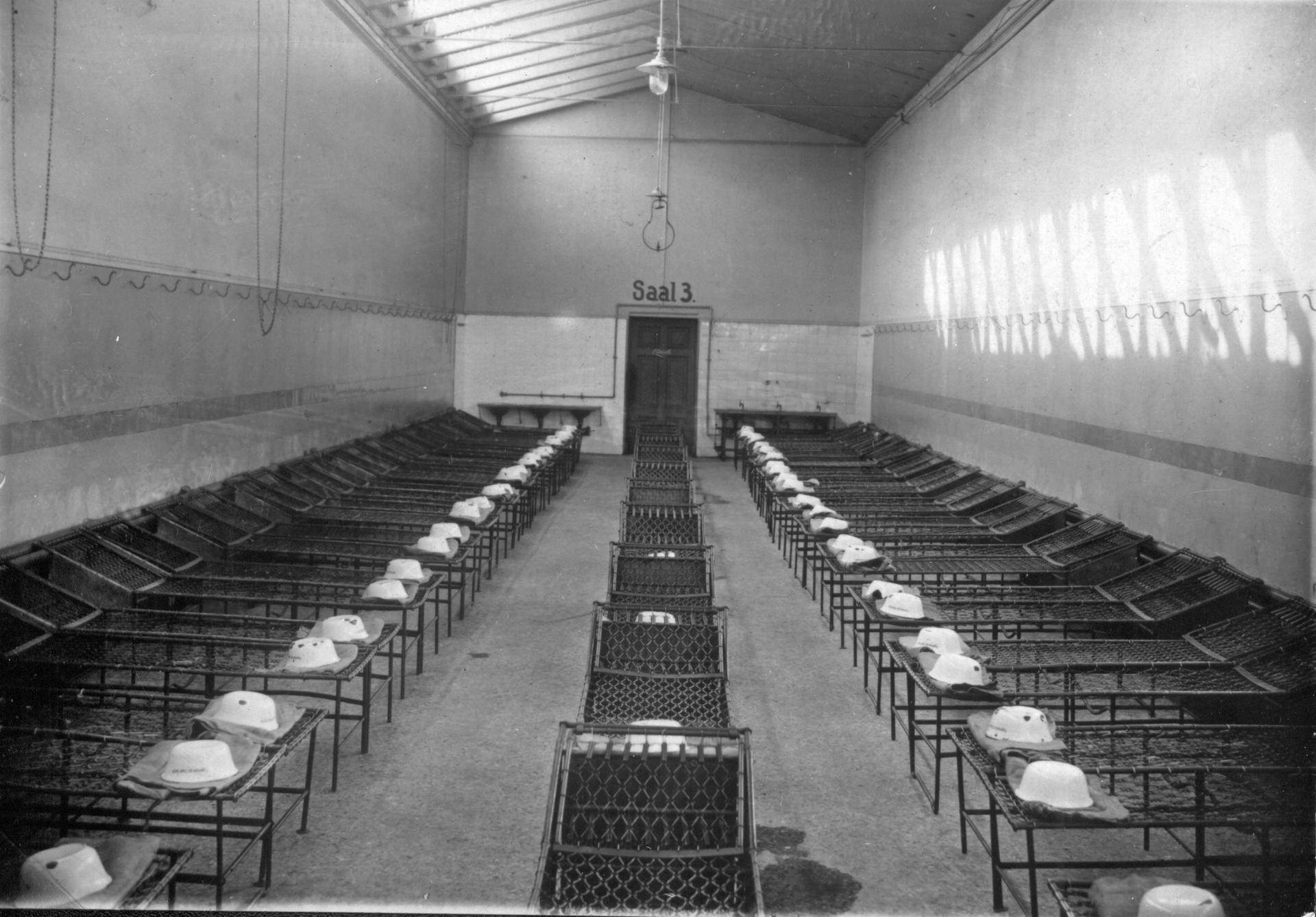 Leerer Schlafsaal (Saal 3) im Asyl Fröbelstraße mit Drahtpritschen vor 1914. Ursprünglich für 50 Personen pro Schlafsaal ausgelegt, mussten später zu 100 Menschen unterkommen.