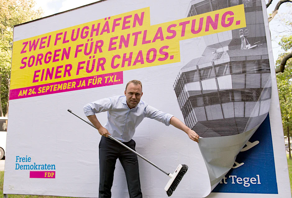 Sebastian Czaja von der Berliner FDP vor einem Plakat seiner Partei anlässlich des Volksentscheids über den Flughafen Tegel.