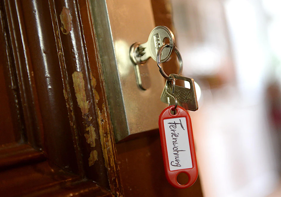 Schlüssel mit Aufschrift „Ferienwohnung” hängt an einer Wohnungstür.