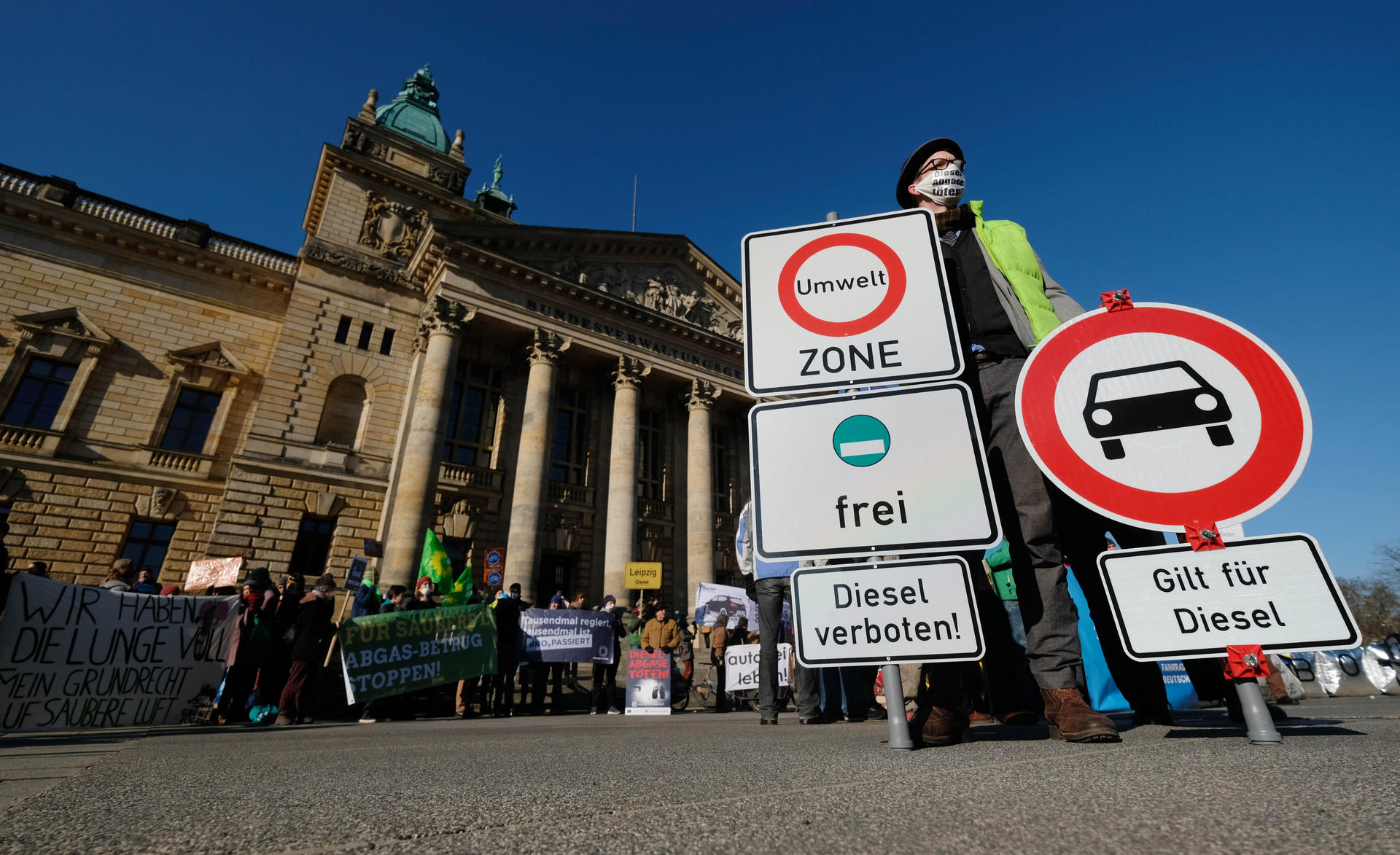 Umweltaktivisten stehen mit Transparenten und Schildern vor dem Bundesverwaltungsgericht.