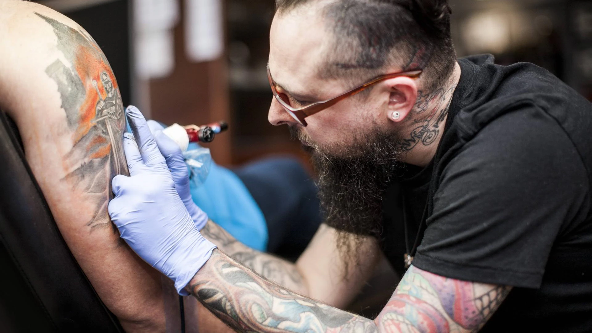 Ein Tätowierer beim Tattoo-Stechen