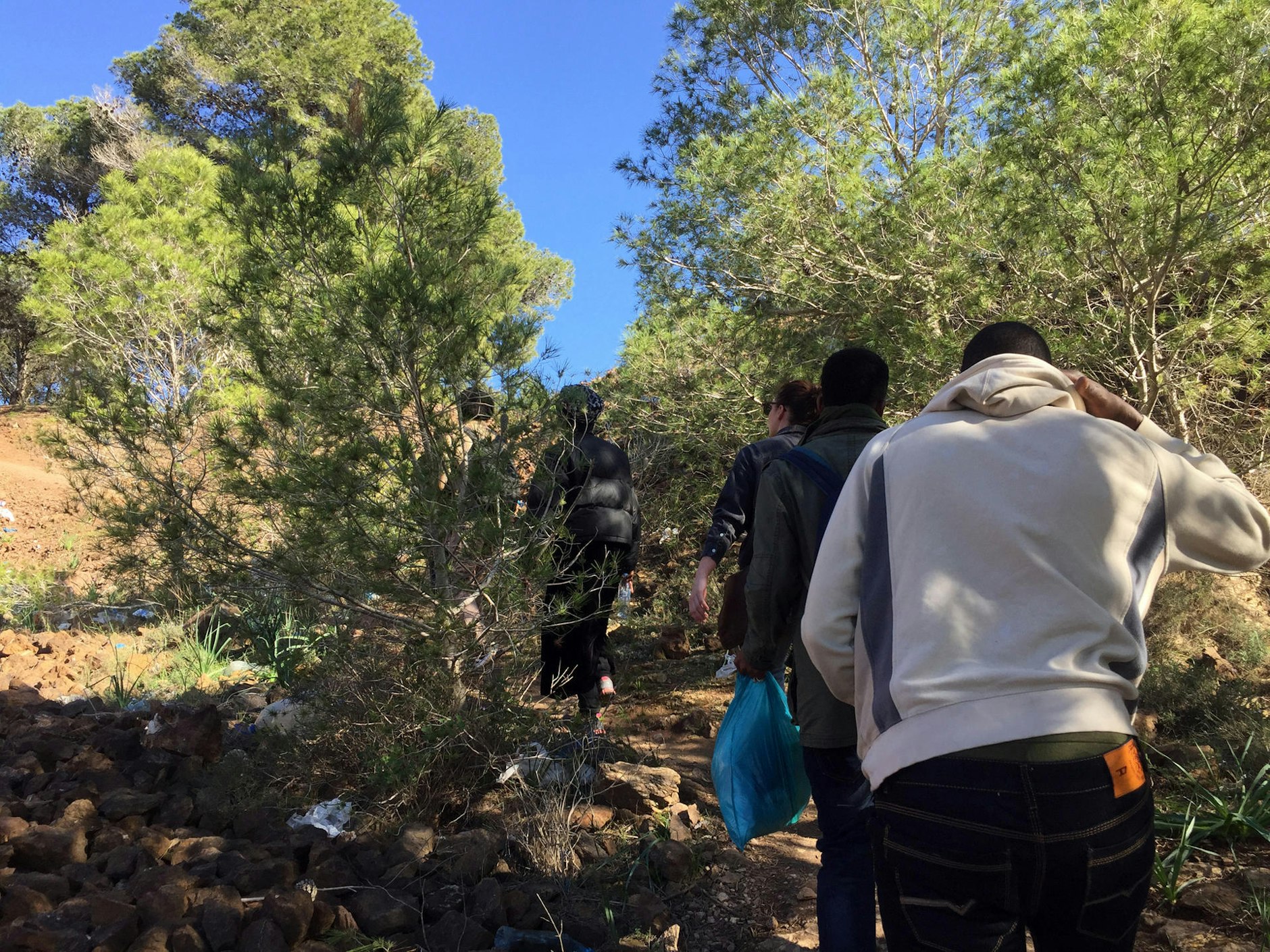 Marokko, Melilla: Afrikanische Flüchtlinge steigen einen Berg hinauf, um zu ihrem illegalen Zeltlager in den Wäldern zu gelangen.