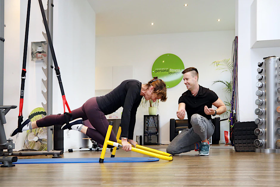 Fitnesstrainer Stefan Müller erklärt unserer Autorin Martina Doering, wie sie sich in dem Seilschlingengerät zu bewegen hat. Sabine Gudath 